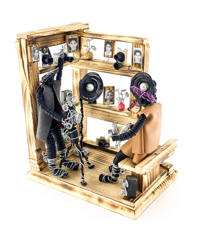 مجسمه مفتولی عکاس در آتلیه عکاسی با طراحی دست‌ساز روی پایه چوبی