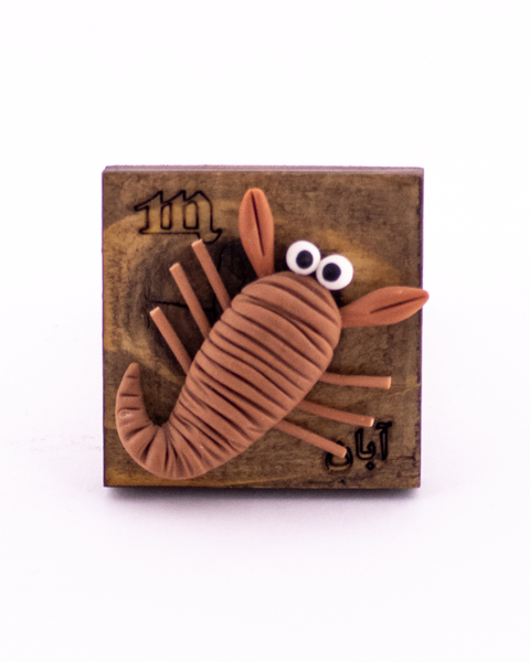 مگنت خمیری دست‌ساز ماه تولد آبان با نماد عقرب روی پایه چوبی– هدیه‌ای مرموز و خاص برای متولدین آبان‌ماه