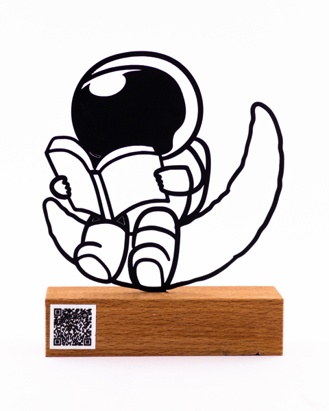 تندیس فلزی فضانورد در حال مطالعه روی ماه با بارکد موسیقی | آرامش در مدار خیال