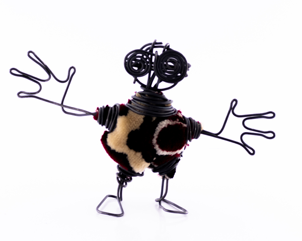 مجسمه مفتولی دست‌ساز با لباس فرشی چندرنگ – آدمک خیال‌پرداز با چشم‌های مارپیچی و دستان اغراق‌شده